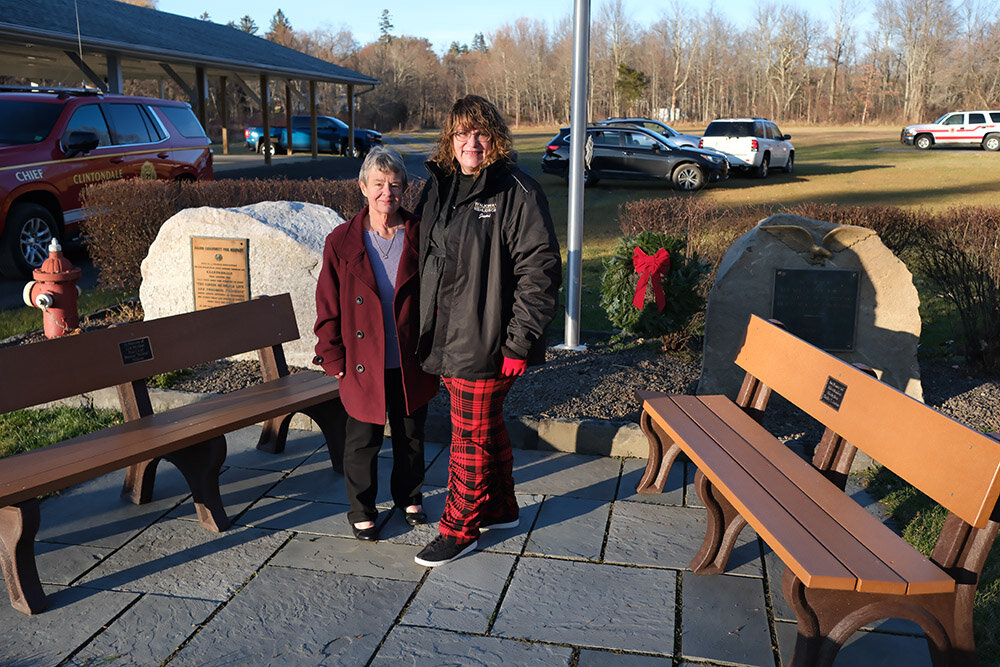 Mary Palazzo and Jami Anson stand beside the two benches that honor the late Mickey Palazzo and Shirley Anson.